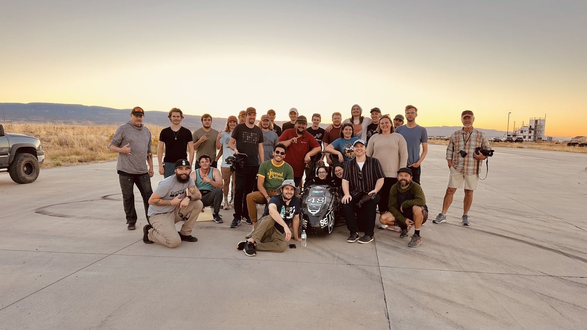 Commercial — full crew at wrap on a desert airfield at sunset